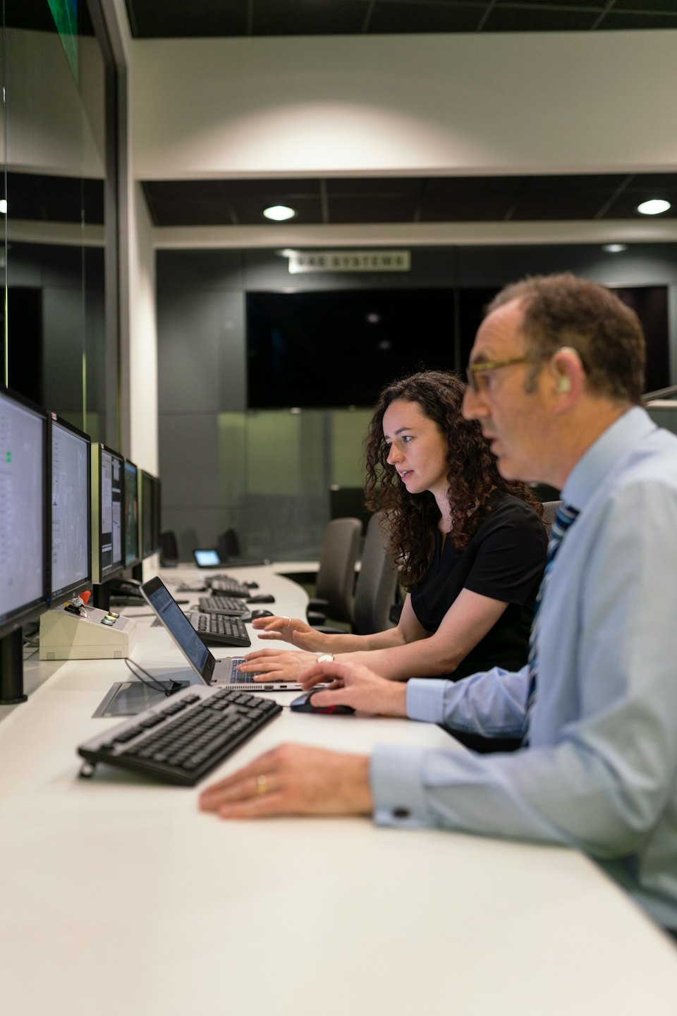Zwei Fachleute arbeiten gemeinsam an Computern in einem modernen Büro.